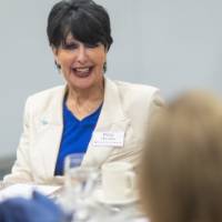 President Mantella smiling at others seated at her table